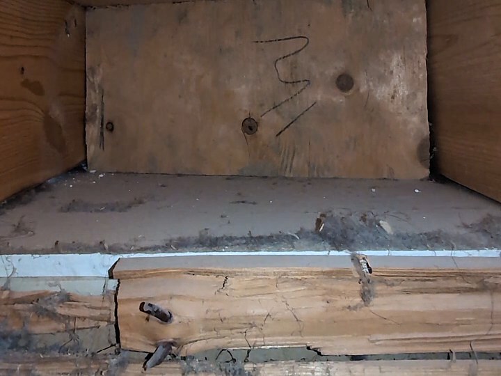 A wood-framed duct section with grime built up along the ledge, before cleaning